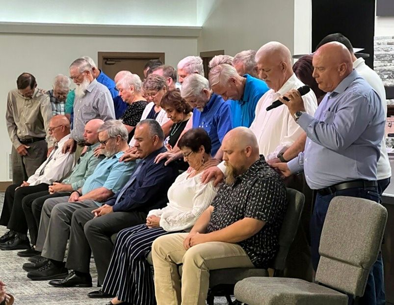 Church members gathered around, praying over the men being ordained